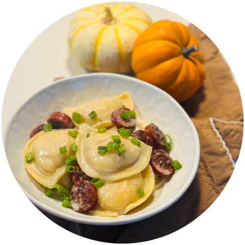 pierogi casserole in a bowl next to small pumpkins