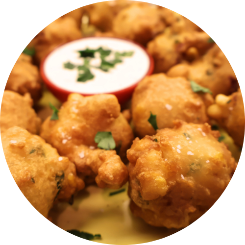 kountry boys sausage and corn fritters on a yellow plate with ranch dip